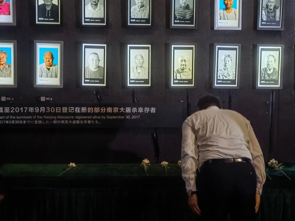 7月18日，人們向離世的南京大屠殺幸存者獻花、鞠躬。新華社記者邱冰清 攝