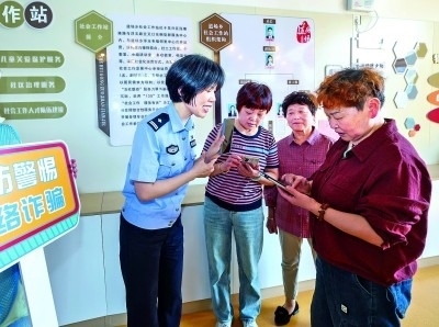 浙江湖州民警指導居民加入湖州“e企安”微信群，實時接收反詐信息。新華社發(fā)