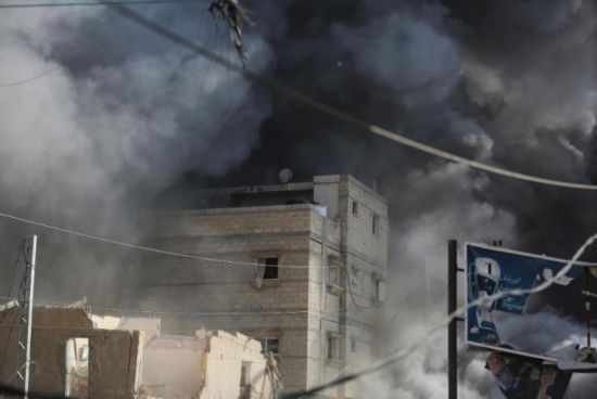 7月21日，在加沙地帶中部的努賽賴特難民營，遭以軍空襲的建筑冒出滾滾濃煙。新華社發(fā)（馬爾萬·達(dá)烏德攝）