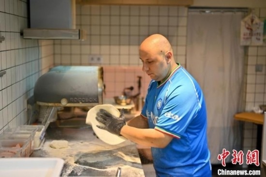 近日，韋榮耀在自家披薩小店內(nèi)忙活。俞靖 攝