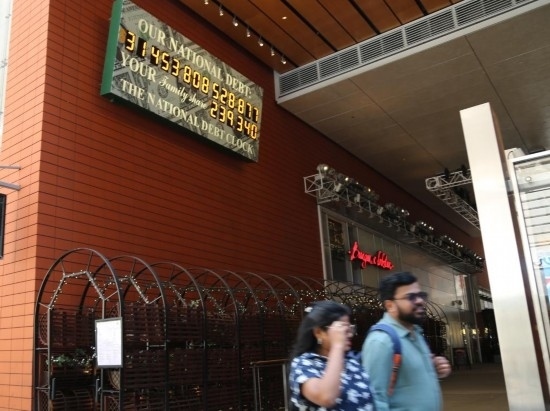 2023年5月29日，人們經(jīng)過美國紐約曼哈頓的“國債鐘”?！皣鴤姟笔且粋€大型計數(shù)器，它實時更新美國的公共債務(wù)總額，并顯示出每個美國家庭所要負擔(dān)的數(shù)額。 新華社記者劉亞南攝