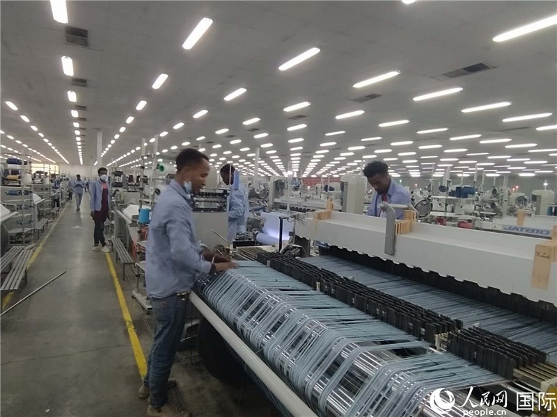 無錫金茂埃塞面料廠車間內(nèi)，當(dāng)?shù)毓と苏谝唤z不茍地作業(yè)。人民網(wǎng)記者 黃培昭攝