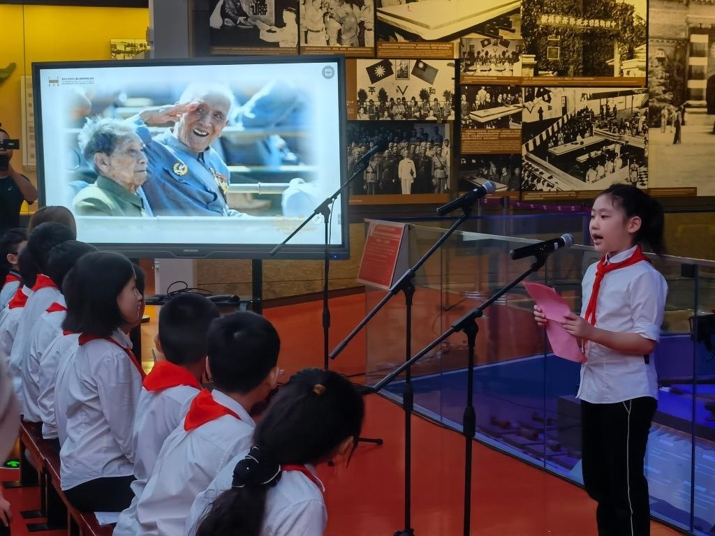 南京市科睿小學(xué)二年級學(xué)生章若初為大家講述抗戰(zhàn)老兵手印的故事。 新華社記者 邱冰清 攝