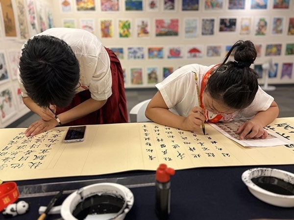 參加本次展覽的青少年在現(xiàn)場進(jìn)行書法創(chuàng)作。主辦方供圖