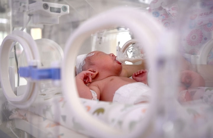 2024年6月1日，在西安國(guó)際醫(yī)學(xué)中心醫(yī)院新生兒科病房，護(hù)士為新生兒喂奶。 新華社記者 劉瀟 攝