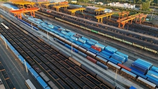 這是2024年8月14日在黑龍江綏芬河鐵路口岸集裝箱換裝場拍攝的集裝箱換裝作業(yè)現(xiàn)場（無人機(jī)照片）。今年前七個(gè)月，綏芬河鐵路口岸開行中歐班列573列，運(yùn)量達(dá)55246標(biāo)箱，同比分別增長23%和18%，班列數(shù)量持續(xù)保持高位運(yùn)行。