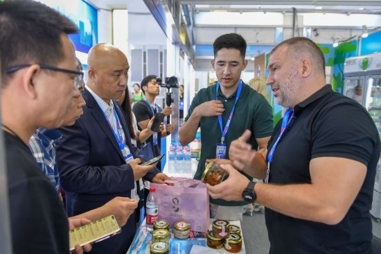 2023年8月23日，在第十四屆中國—東北亞博覽會(huì)東北亞商品館，俄羅斯參展商向參觀者介紹商品。