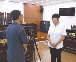 圖為全國人大代表玉明姬（右）詳細了解環(huán)境資源審判工作情況。劉思妤 攝