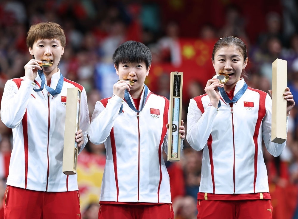 冠軍中國隊選手王曼昱、孫穎莎、陳夢（從左至右）在巴黎奧運會乒乓球女子團體頒獎儀式上（2024年8月10日攝）。新華社記者 王東震 攝