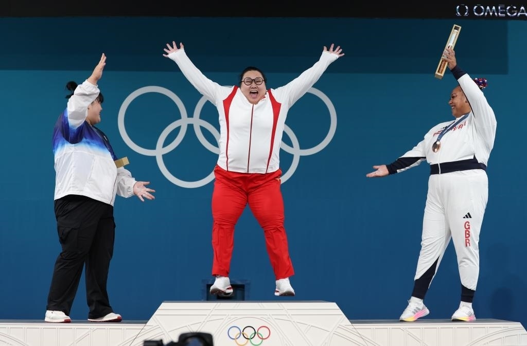 中國選手李雯雯（中）在巴黎奧運會舉重女子81公斤以上級頒獎儀式中登上領(lǐng)獎臺（2024年8月11日攝）。新華社記者 楊磊 攝