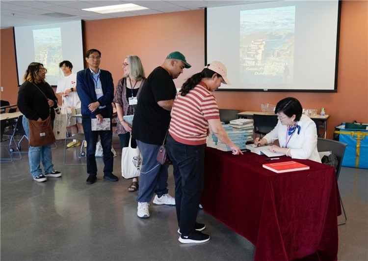 作者顧春芳在活動現(xiàn)場簽名贈書。羅先勇攝