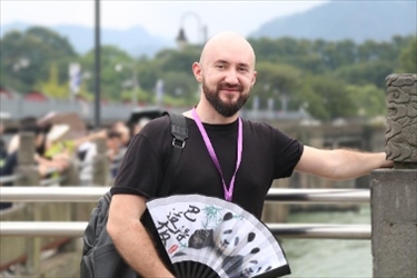 俄羅斯塔斯社執(zhí)行編輯葉夫根尼·扎多羅日內(nèi)在都江堰魚嘴拍照留念。（李佩藺 攝）