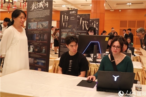 在活動(dòng)現(xiàn)場(chǎng)，當(dāng)?shù)孛癖婓w驗(yàn)“數(shù)字藏經(jīng)洞”云游戲，沉浸式體驗(yàn)敦煌文化。 人民網(wǎng)記者 李志偉攝