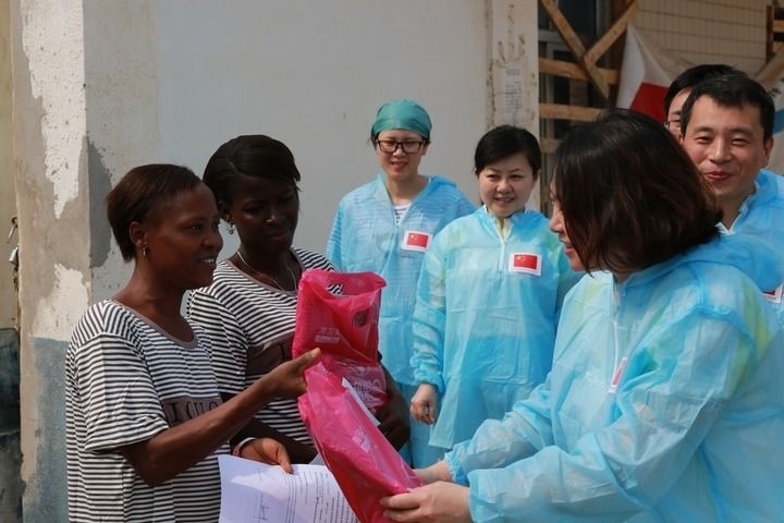 2015年4月4日，在位于塞拉利昂首都弗里敦市郊的中塞友好醫(yī)院埃博拉診療中心，中國第四批援塞醫(yī)療隊副隊長邵蔚（右前）向被治愈的埃博拉出血熱患者贈送禮物。新華社發(fā)（祖榮強(qiáng) 攝）