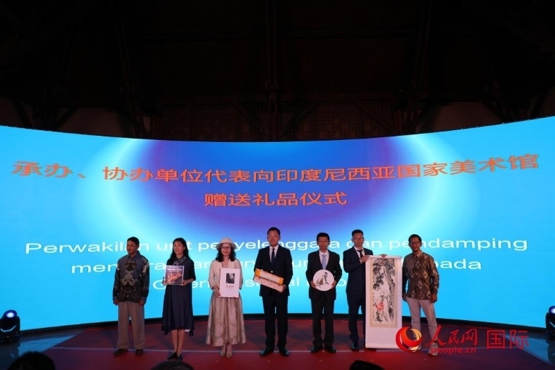 在展覽開幕式現(xiàn)場，本次展覽的承辦、協(xié)辦單位代表向印尼國家美術館贈送禮品。人民網記者 曹師韻攝