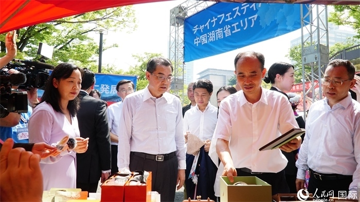 湖南展位工作人員向中國駐日本大使吳江浩介紹特色文創(chuàng)產(chǎn)品。人民網(wǎng) 蔣曉辰攝