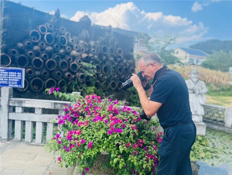 遠(yuǎn)處黔北民居錯(cuò)落有致，近處一只黑色的蝴蝶穿梭于粉紫色三角梅花叢間隙，與俄羅斯“大歐亞”總編輯弗拉基米爾·別列日內(nèi)赫的鏡頭玩起了捉迷藏，“你追我逃，不亦樂(lè)乎”。（張亞欣攝）