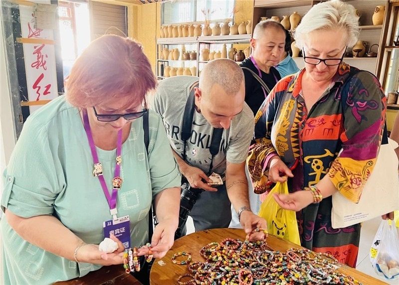歐亞媒體考察團(tuán)成員在母氏陶藝館內(nèi)挑花了眼，色彩絢麗、質(zhì)地均勻的陶藝手串讓他們愛(ài)不釋手。“這里的東西都太實(shí)惠了！”塔吉克斯坦《索格特真理報(bào)》政論部主任娜塔利婭·多羅費(fèi)耶娃說(shuō)?；宓奶厣a(chǎn)品物美價(jià)廉，讓考察團(tuán)成員為家人好友買到了心儀的禮物，也為此次以四川成都為起點(diǎn)，路經(jīng)南充、廣安至貴州遵義的考察行程畫(huà)上了圓滿句號(hào)。（張亞欣攝）