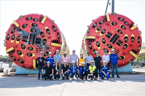 中外員工在盾構(gòu)機(jī)前合影。中國電建供圖