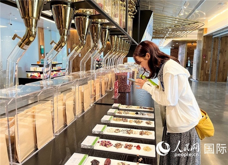 4. 代表團(tuán)團(tuán)員對(duì)新中式茶飲的食材充滿興趣。（人民網(wǎng)記者陳思 攝）