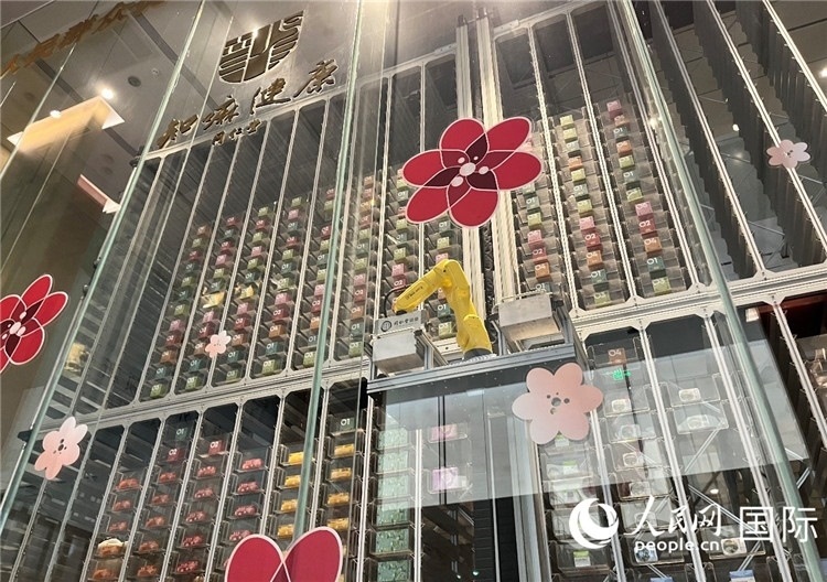 6. 機(jī)械臂正在取貨。（人民網(wǎng)記者陳思 攝）