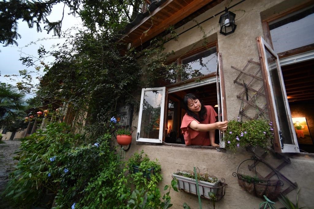 8月29日，在福建省屏南縣熙嶺鄉(xiāng)，龍?zhí)洞濉靶麓迕瘛泵泛暝诖蚶碜约航?jīng)營的民宿外墻裝飾花盆。新華社記者姜克紅 攝