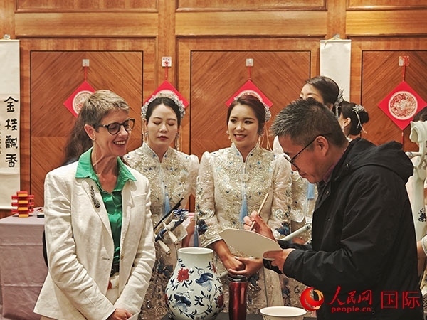 現(xiàn)場(chǎng)的非遺傳承人為英國觀眾展示畫技。人民網(wǎng)記者 邢雪攝