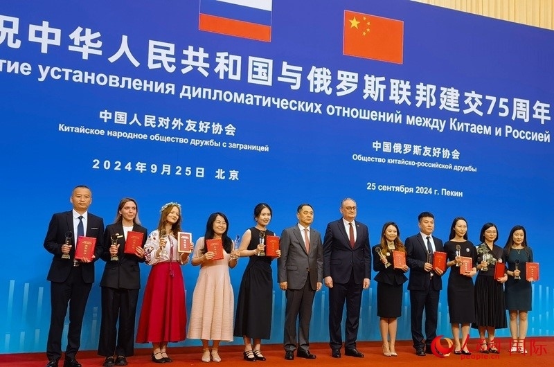 楊萬(wàn)明會(huì)長(zhǎng)和莫爾古洛夫大使為10位中俄青年友好微視頻創(chuàng)意大賽獲獎(jiǎng)代表頒獎(jiǎng)。人民網(wǎng)記者 李明琪攝