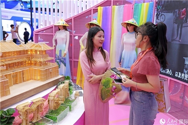 參觀者在東博會越南展區(qū)同工作人員咨詢交談。人民網(wǎng)記者 趙益普攝