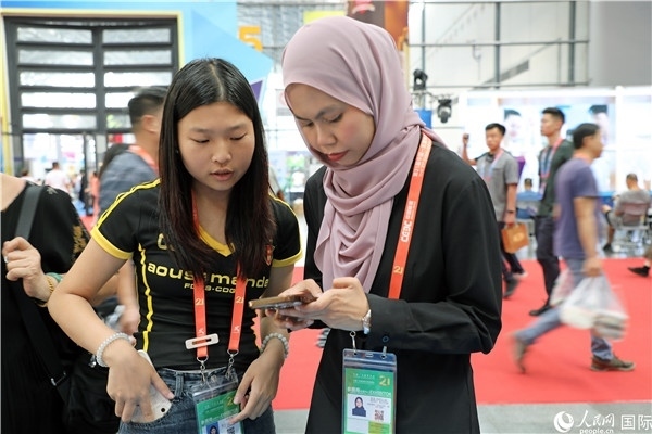 東博會現(xiàn)場，馬來西亞展商在同中方工作人員交談。人民網(wǎng)記者 趙益普攝