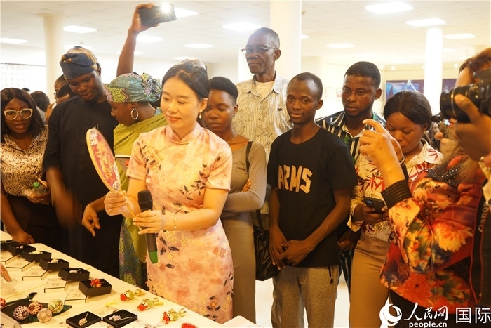 向尼日利亞觀眾介紹中國(guó)刺繡。人民網(wǎng)記者 姜宣攝