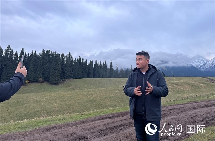 在庫爾德寧，吾買爾江被雪山美景震撼，即興錄制了短視頻作品。人民網(wǎng)記者曾書柔攝