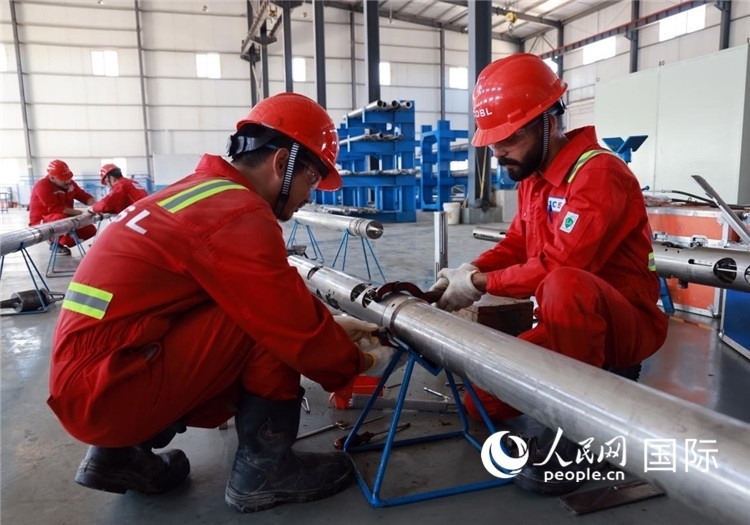 中伊員工共同在檢修鉆井設備。人民網(wǎng)記者管克江攝