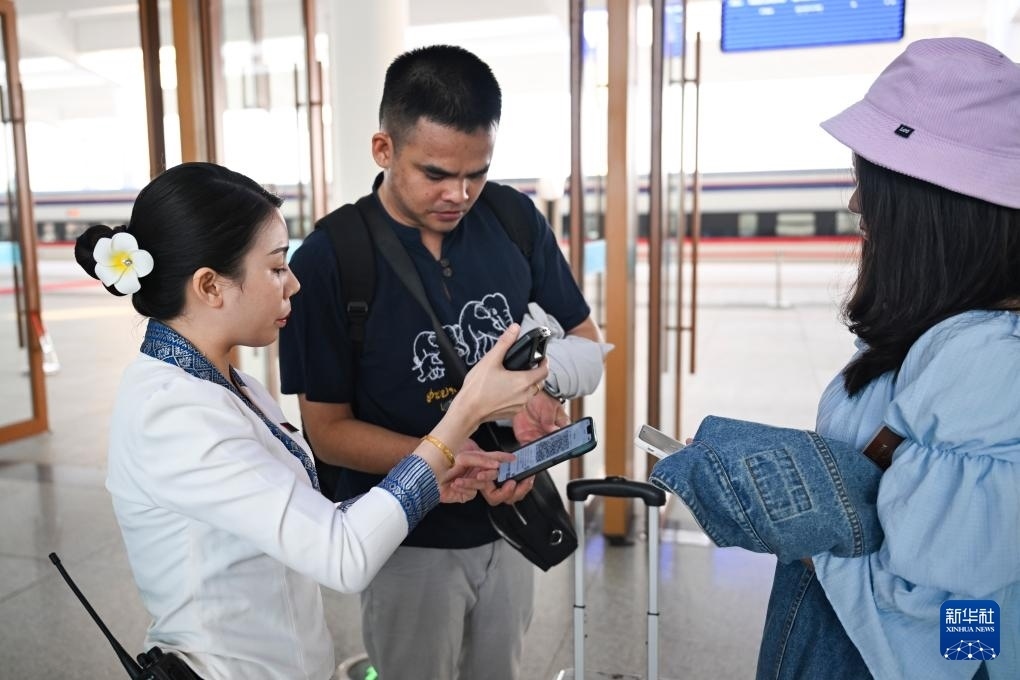 10月12日，在老撾萬象中老鐵路萬象站，工作人員檢驗乘客車票。新華社記者 程一恒 攝