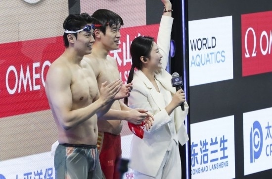  10月18日，汪順（左）和潘展樂在男子100米混合泳決賽后。新華社記者 方喆 攝