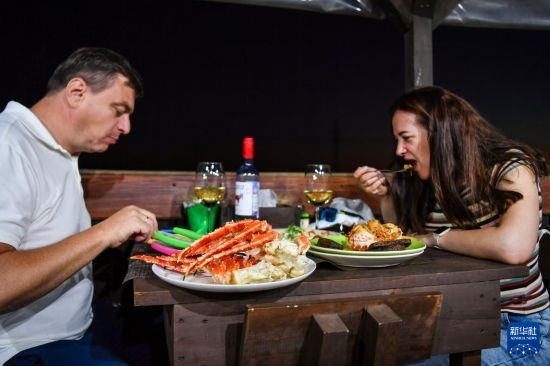 9月2日，食客們?cè)诙砹_斯符拉迪沃斯托克的一家餐館品嘗帝王蟹。新華社記者 曹陽 攝