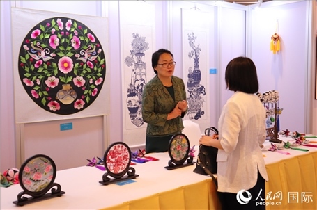 青海非遺文化傳承人向嘉賓介紹展品。人民網(wǎng)實(shí)習(xí)生姚欣可攝