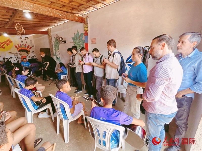  受益于中國企業(yè)的“青少年成長”項目，700多名當?shù)厍嗌倌甑囊魳泛妥闱驂粝氩迳狭顺岚?。圖為聯(lián)合采訪團正在采訪參加音樂培訓的孩子們。 人民網(wǎng)記者 陳一鳴攝