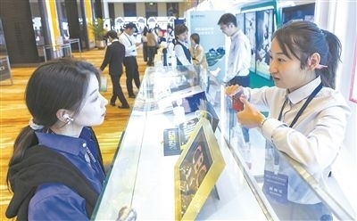 在北京麗澤商務(wù)區(qū)，工作人員（右一）介紹數(shù)字人民幣SIM卡硬錢包。新京報記者 陶冉攝