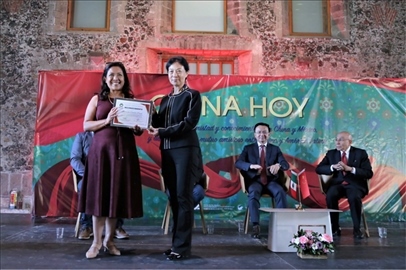 李雅芳向加比拉爾·塞迪略授予“拉美分社榮譽(yù)員工”稱號(hào)。主辦方供圖