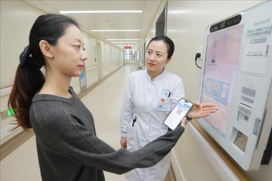 醫(yī)護(hù)人員引導(dǎo)患者在自助機(jī)前辦理自助入院手續(xù)。圖片來源：山東第一醫(yī)科大學(xué)第二附屬醫(yī)院