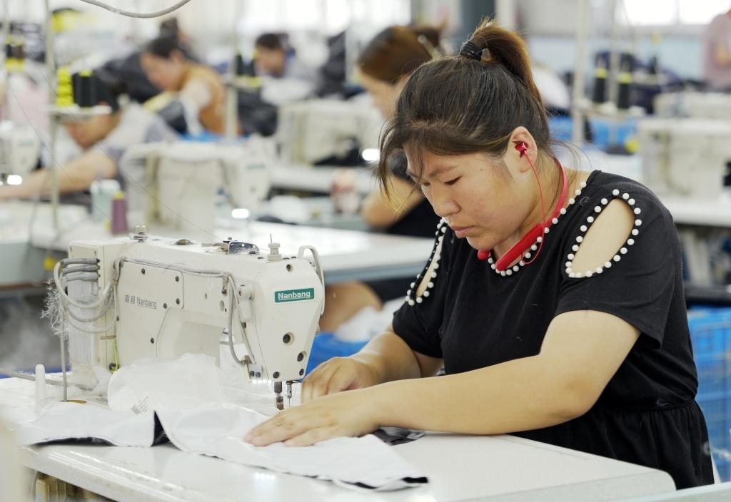 5月20日，村民在李寨村服裝加工廠內(nèi)忙碌。河南省周口市沈丘縣馮營(yíng)鎮(zhèn)李寨村地處豫東平原。近年來(lái)，乘著脫貧攻堅(jiān)與鄉(xiāng)村振興政策的東風(fēng)，李寨村積極探索產(chǎn)業(yè)發(fā)展模式，通過(guò)“龍頭企業(yè)+村集體經(jīng)濟(jì)+農(nóng)戶”的方式，逐漸發(fā)展形成肉牛養(yǎng)殖、設(shè)施農(nóng)業(yè)、服裝加工、康養(yǎng)民宿等產(chǎn)業(yè)，以產(chǎn)業(yè)振興助力鄉(xiāng)村振興。新華社記者 李嘉南 攝