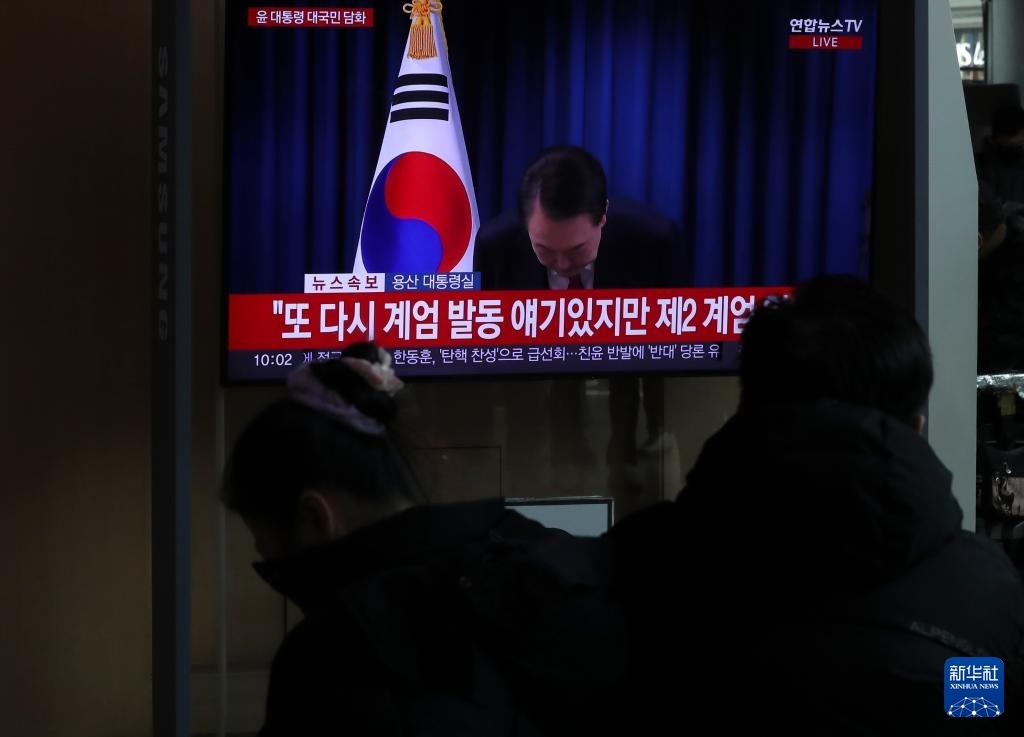 12月7日，在韓國首爾火車站，民眾觀看總統(tǒng)尹錫悅發(fā)表講話的電視畫面。新華社記者 姚琪琳 攝