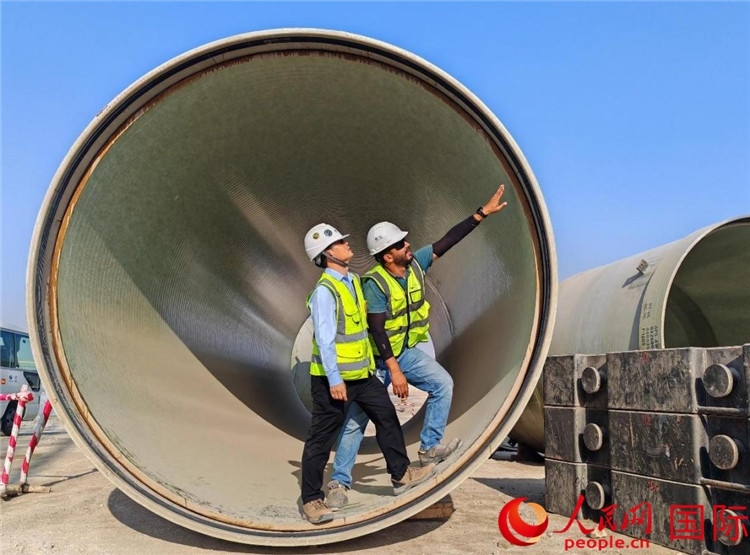 工作人員在察看輸水管情況。人民網(wǎng)記者 管克江攝