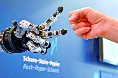在德國(guó)漢諾威工博會(huì)上，參觀者與一款智能機(jī)器人進(jìn)行“石頭剪子布”游戲。新華社發(fā)