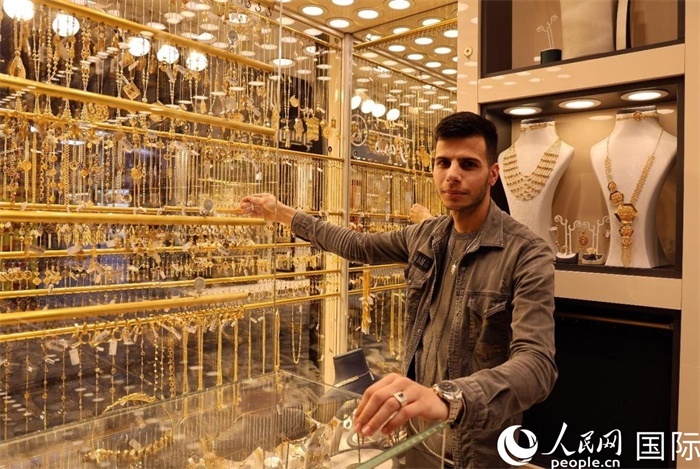 一名銷售員展示黃金飾品。人民網(wǎng) 伊納斯·易卜拉欣攝