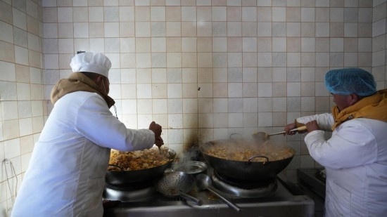 1月14日，服務(wù)隊的兩名廚師正在為村民們做午飯。新華社記者 邱星翔 攝