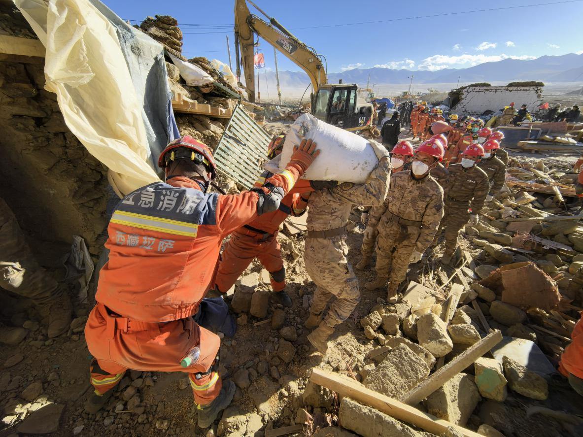 1月11日，定日縣長(zhǎng)所鄉(xiāng)古榮村，應(yīng)急消防等救援人員排隊(duì)接力搶運(yùn)掩埋在倒塌房屋下的群眾財(cái)物。人民日?qǐng)?bào)記者楊翹楚攝