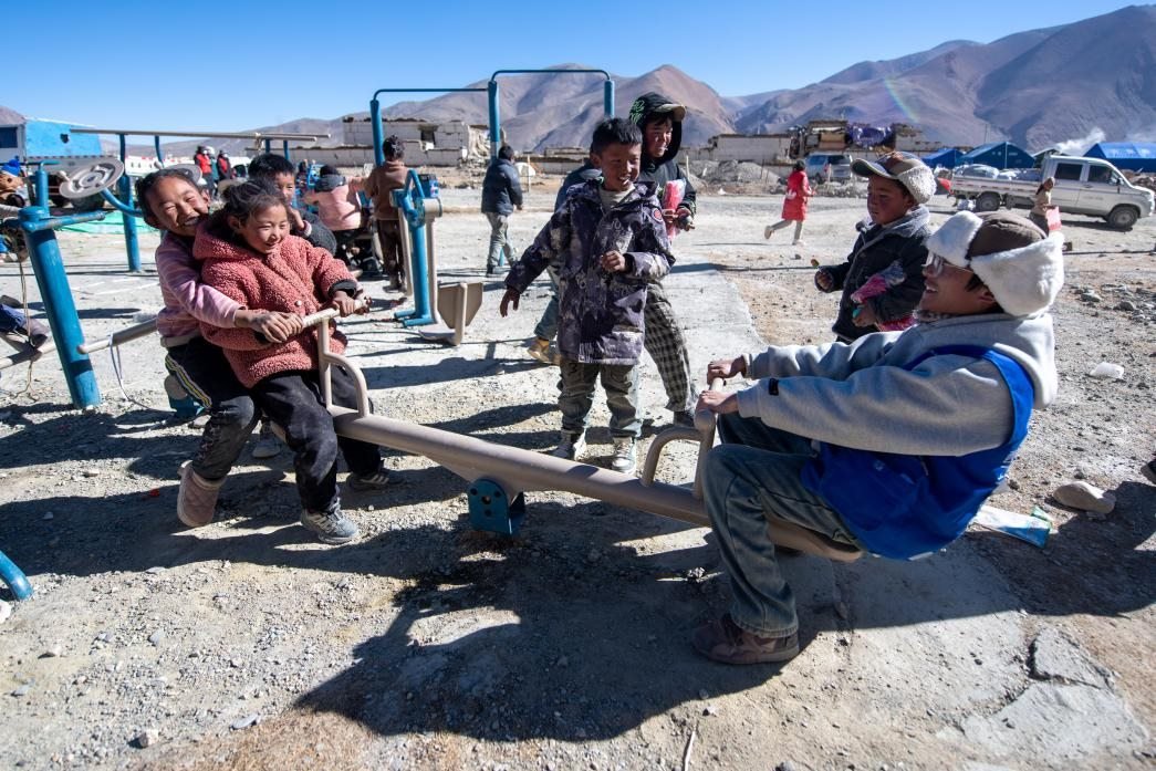 1月11日，在定日縣措果鄉(xiāng)塘仁村安置點(diǎn)，西藏星光社會(huì)工作服務(wù)中心志愿者和孩子們一起玩耍，進(jìn)行災(zāi)后心理疏導(dǎo)。人民網(wǎng)記者 翁奇羽攝
