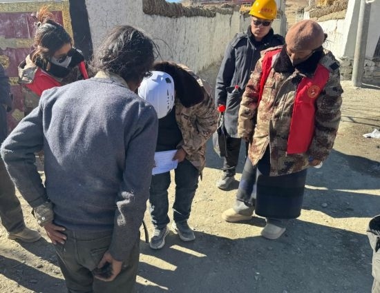 1月13日，次旺（右一）陪同工作組走訪村莊，評(píng)估房屋受損程度。新華社發(fā)